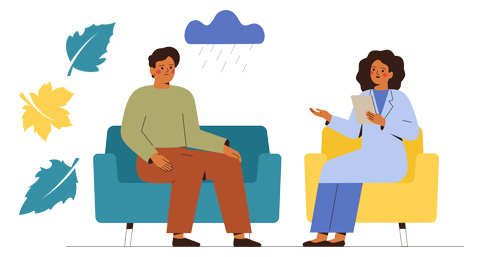 a counsellor speaking with a sad person while sat on chairs